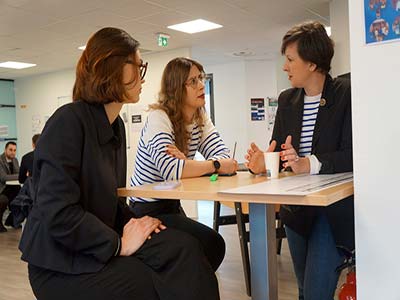 2 jeunes filles en entretien avec une dame autour d'une table